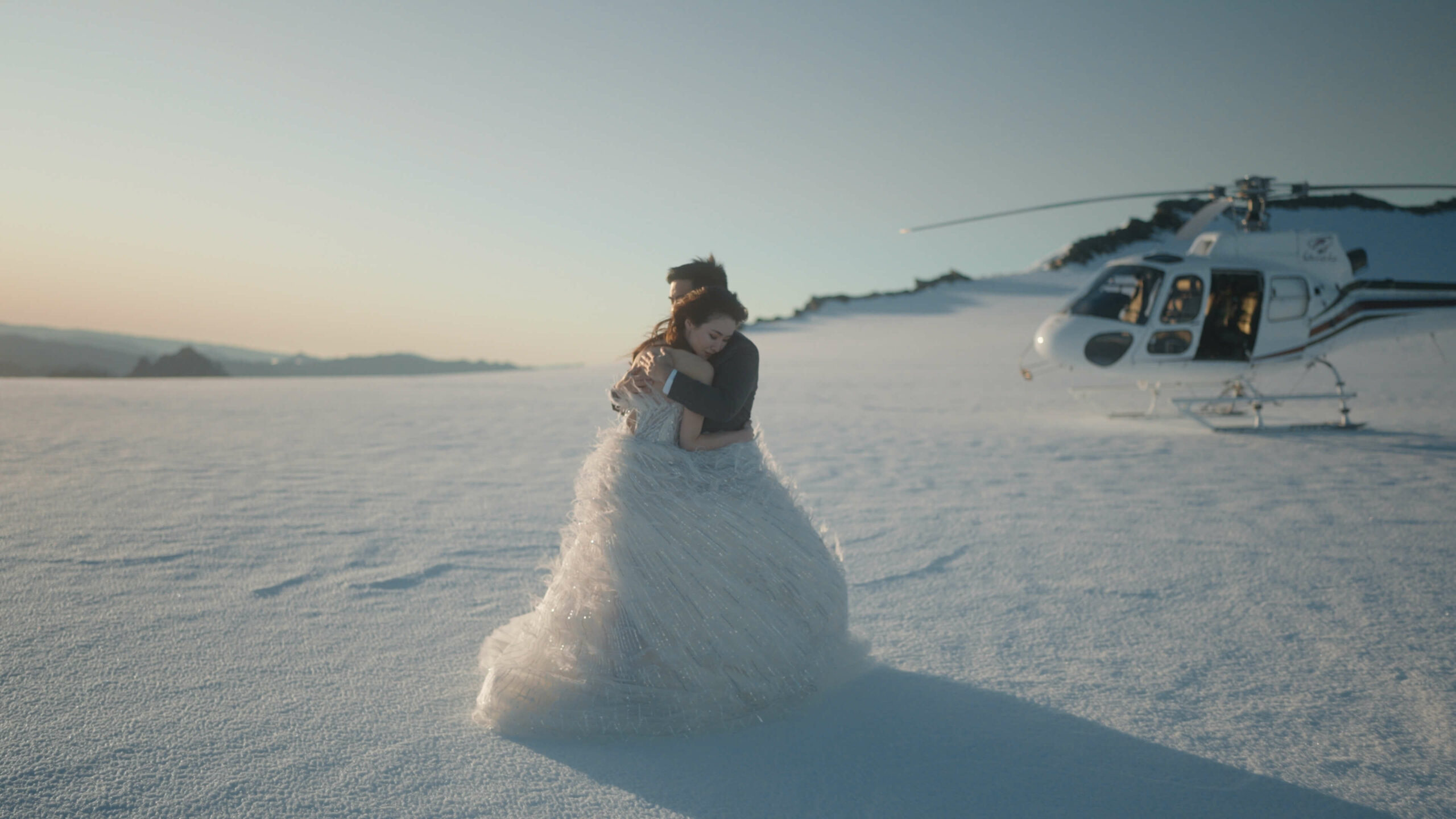 bride and groom hugging on glacier